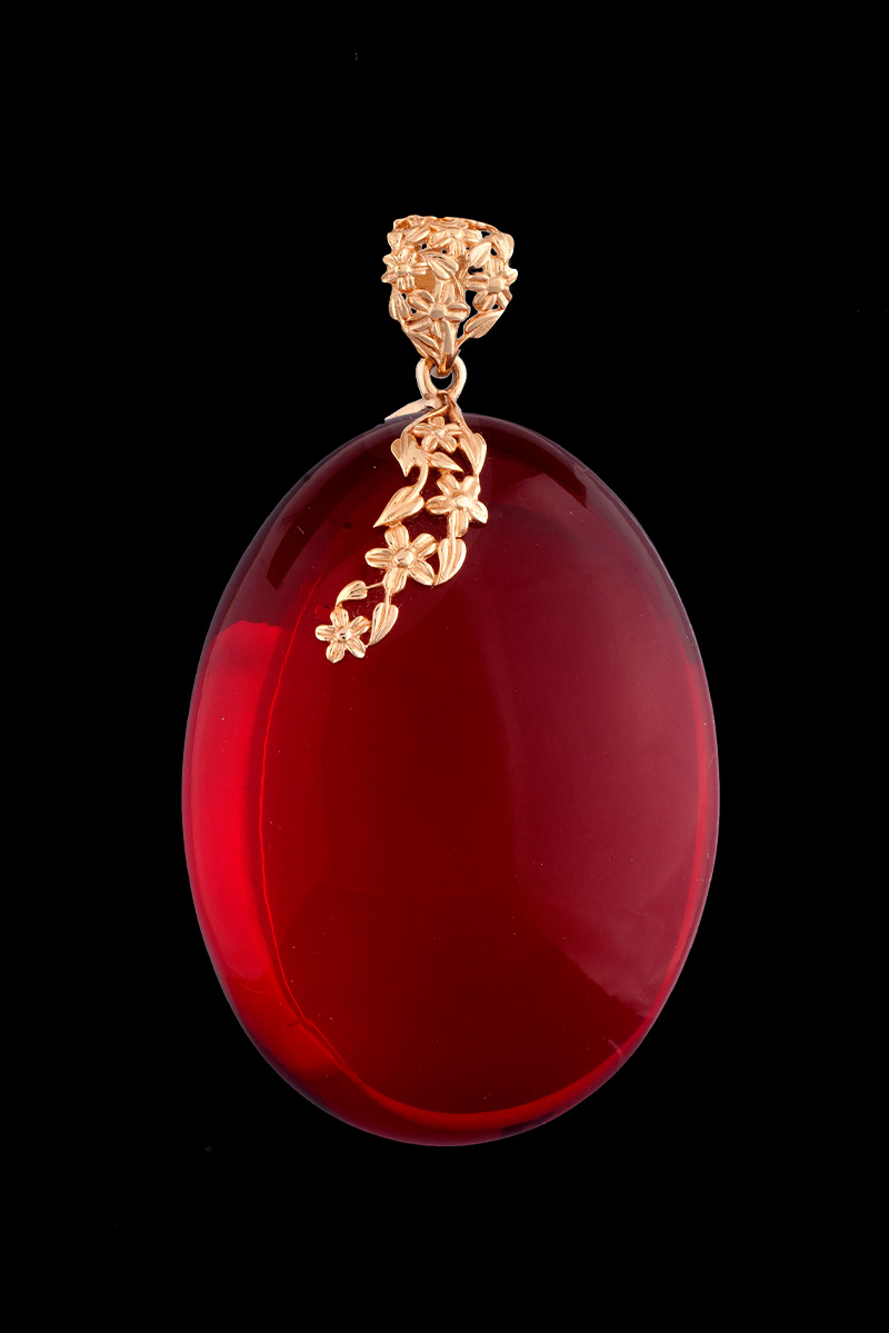 Wisiorek z czerwonego bursztynu ze złotą ozdobą kwiatową